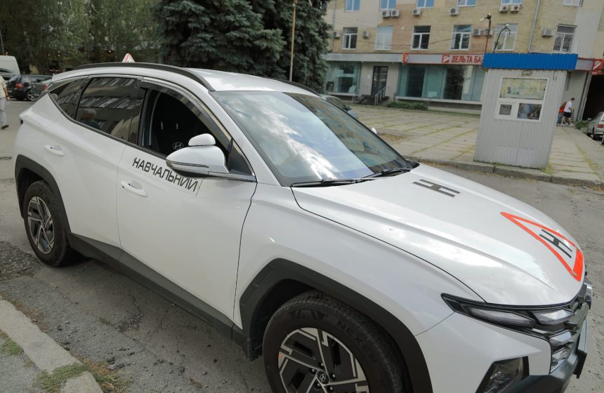 Білий навчальний автомобіль автошколи «Віраж» на вулиці у Харкові.
